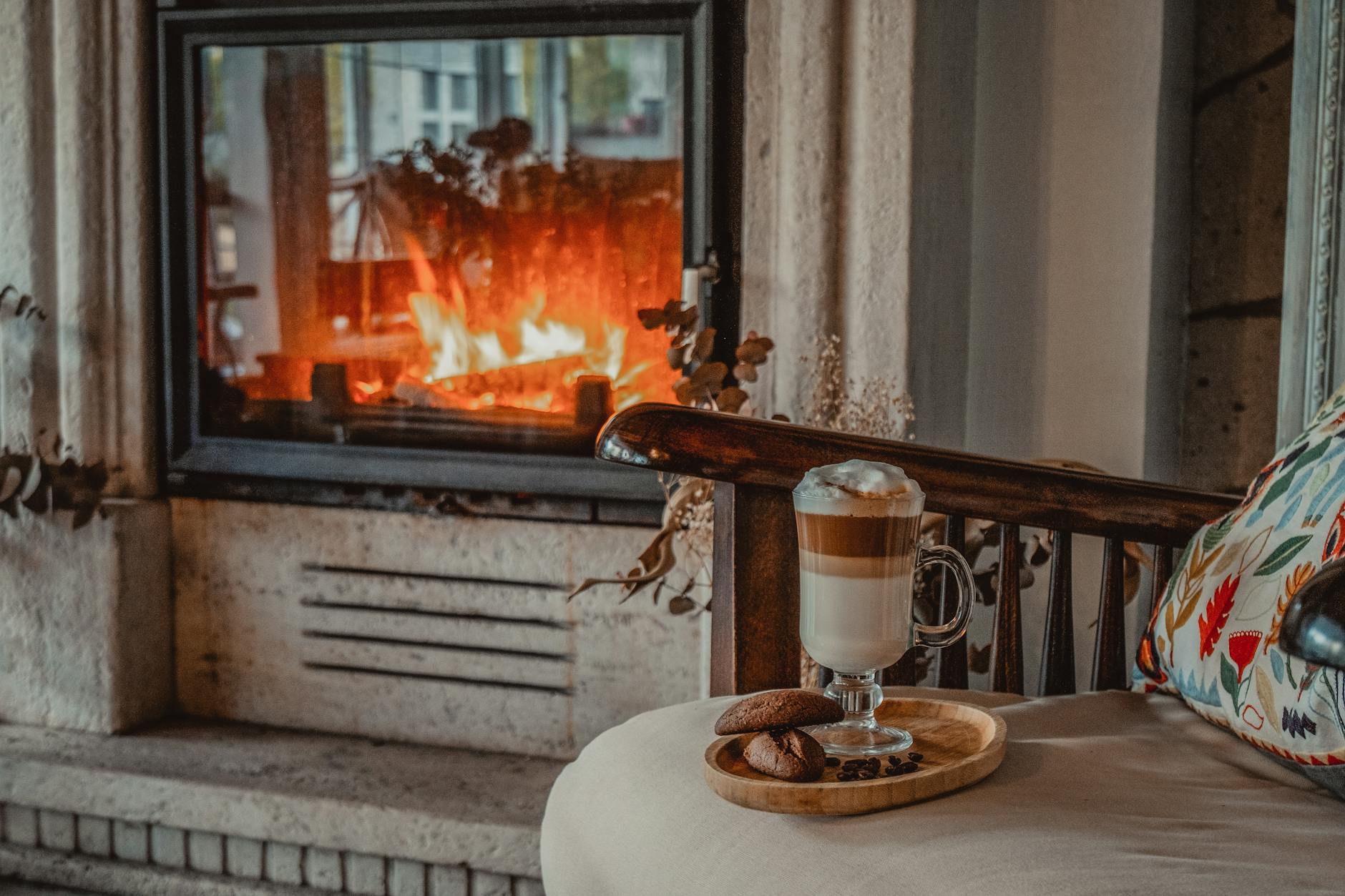 Warm and cozy living room scene with hot coffee and cookies by a fireplace, perfect for a relaxing atmosphere.